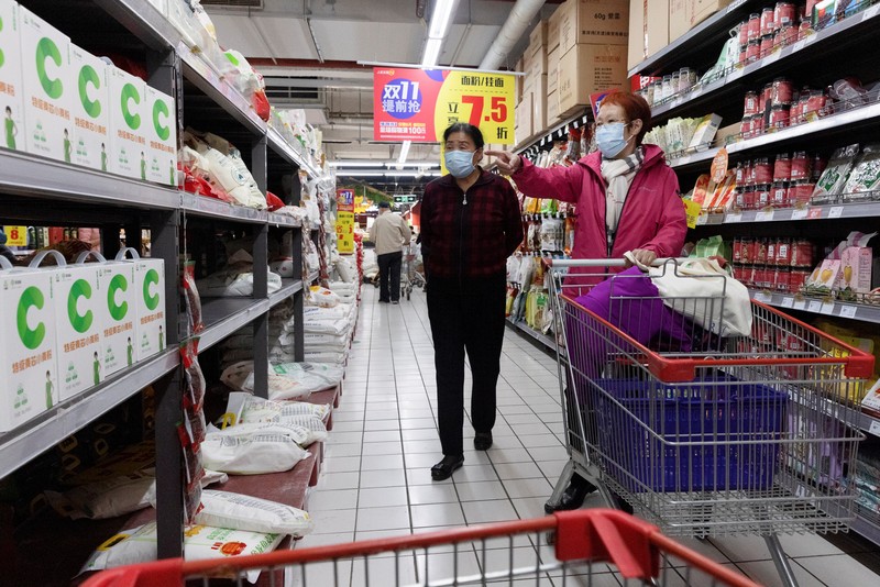 People look at products in the flour section of a supermarket following outbreak of the coronavirus disease (COVID-19) in Beijing, China, November 3, 2021. REUTERS/Thomas Peter