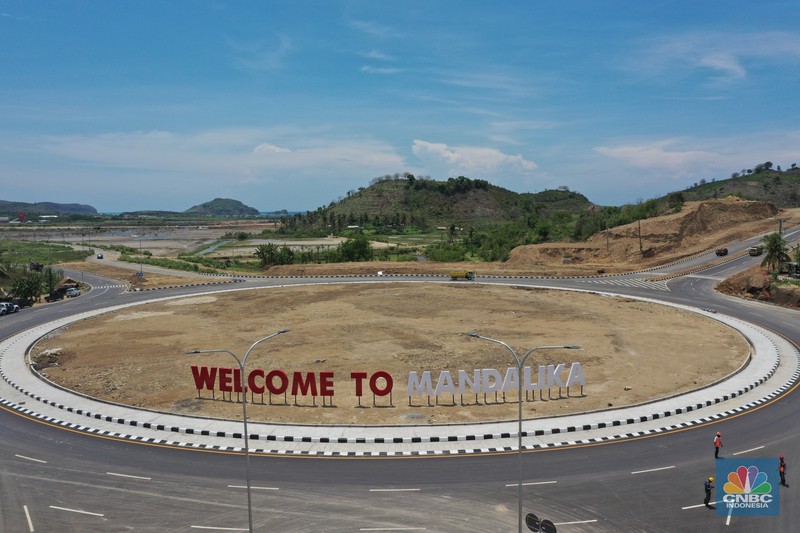 Bypass Bil Mandalika, Lombok Foto udara menunjukkan pendendara melewati jalan Bypass Bil Mandalika, Lombok, Nusa Tenggara Barat, Kamis (4/1/2021). Kementerian Pekerjaan Umum & Perumahan Rakyat (PUPR) melalui Badan Pengembangan Infrastruktur Wilayah (BPIW) membangun jalan elak atau bypass yang menghubungkan Bandara Internasional Lombok dengan Kawasan Pariwisata Mandalika sejauh 17 kilometer. Keberadaan jalan ini bakal mendukung aktivitas pariwisata di Mandalika seiring rencana penyelenggaraan balap motor MotoGP pada 2021 mendatang. Pembangunan jalan ini akan meningkatkan konektivitas dari Bandara BIL ke Kawasan Wisata Mandalika dan mendukung akses menuju sirkuit MotoGP yang dibangun di Kawasan Mandalika. Jalan ini juga akan mengurangi waktu tempuh dari BIL ke Mandalika menjadi 15 menit. Sebab, jika semula melewati jalan lama bisa lebih dari 45 menit. Jalan Bypass BIL-Mandalika memiliki panjang 17,363 kilometer dengan lebar right of way (ROW) 50 meter serta 4 lajur yang dilengkapi median jalan. Menelan anggaran sekitar Rp 706 miliar pada 2020–2021. Pembangunannya terdiri dari tiga paket pekerjaan. Yakni Paket I sepanjang 4,30 km (STA 0+000-STA 4+300) dengan kontraktor PT Nindya Karya-Bumi Agung (KSO) dengan anggaran sebesar Rp199 miliar. Kemudian Paket 2 sepanjang 9,70 km (STA 4+300-STA 14+000) kontraktornya PT Adhi Karya (Persero) Tbk-PT Metro Lestari Utama (KSO) dengan anggaran senilai Rp 353 miliar. Selanjutnya untuk Paket 3 sepanjang 3,363 km (STA 14+00-STA 17+363), kontraktornya PT Yasa Patria Perkasa dengan anggaran senilai Rp 152 miliar. (CNBC Indonesia/ Tri Susilo)
