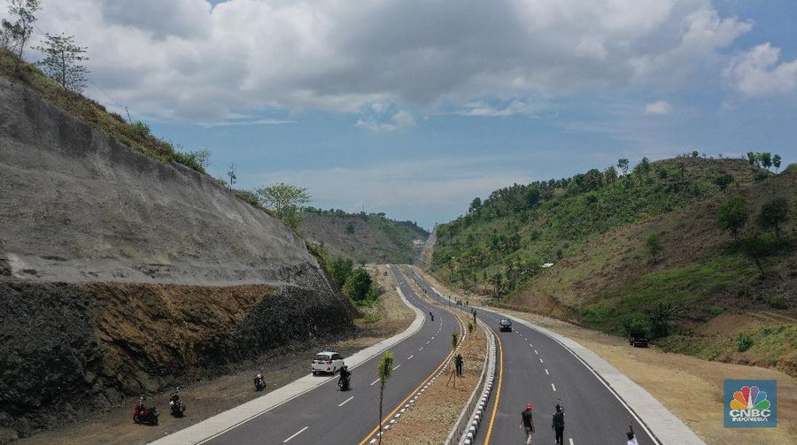 Foto udara menunjukkan pendendara melewati jalan Bypass Bil Mandalika, Lombok, Nusa Tenggara Barat, Kamis (4/1/2021).  Kementerian Pekerjaan Umum & Perumahan Rakyat (PUPR) melalui Badan Pengembangan Infrastruktur Wilayah (BPIW) membangun jalan elak atau bypass yang menghubungkan Bandara Internasional Lombok dengan Kawasan Pariwisata Mandalika sejauh 17 kilometer. Keberadaan jalan ini bakal mendukung aktivitas pariwisata di Mandalika seiring rencana penyelenggaraan balap motor MotoGP pada 2021 mendatang. Pembangunan jalan ini akan meningkatkan konektivitas dari Bandara BIL ke Kawasan Wisata Mandalika dan mendukung akses menuju sirkuit MotoGP yang dibangun di Kawasan Mandalika. Jalan ini juga akan mengurangi waktu tempuh dari BIL ke Mandalika menjadi 15 menit. Sebab, jika semula melewati jalan lama bisa lebih dari 45 menit.  Jalan Bypass BIL-Mandalika memiliki panjang 17,363 kilometer dengan lebar right of way (ROW) 50 meter serta 4 lajur yang dilengkapi median jalan. Menelan anggaran sekitar Rp 706 miliar pada 2020–2021. Pembangunannya terdiri dari tiga paket pekerjaan. Yakni Paket I sepanjang 4,30 km (STA 0+000-STA 4+300) dengan kontraktor PT Nindya Karya-Bumi Agung (KSO) dengan anggaran sebesar Rp199 miliar. Kemudian Paket 2 sepanjang 9,70 km (STA 4+300-STA 14+000) kontraktornya PT Adhi Karya (Persero) Tbk-PT Metro Lestari Utama (KSO) dengan anggaran senilai Rp 353 miliar. Selanjutnya untuk Paket 3 sepanjang 3,363 km (STA 14+00-STA 17+363), kontraktornya PT Yasa Patria Perkasa dengan anggaran senilai Rp 152 miliar.  (CNBC Indonesia/ Tri Susilo)