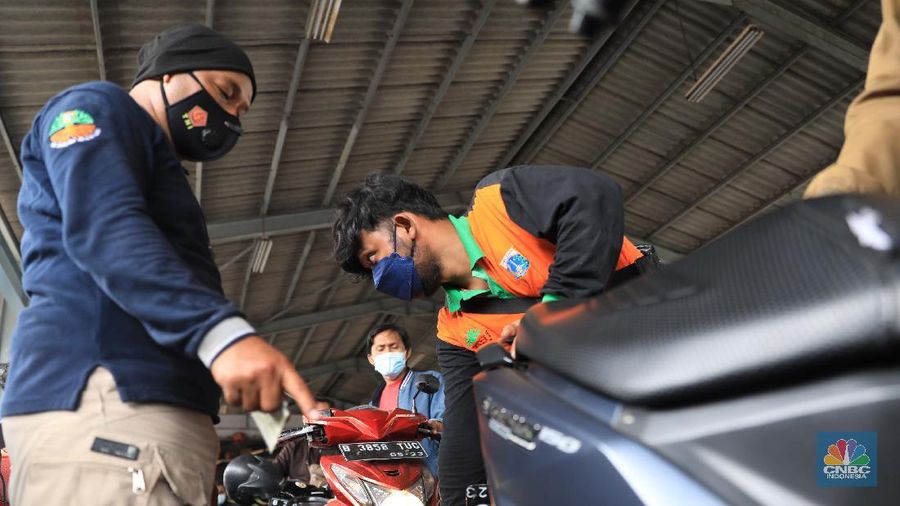 Warga mengikuti uji emisi kendaraan motor secara gratis di Dinas Lingkungan hidup Cililitan, Jakarta Timur, Kamis (4/11/2021). Pemprov DKI DKI Jakarta mewajibkan uji emisi bagi kendaraan roda dua maupun roda empat yang umurnya lebih dari 3 tahun mulai 13 November 2021. Antusiasme warga karena pelayan gratis, membuat antrean uji emisi kendaraan membeludak. 