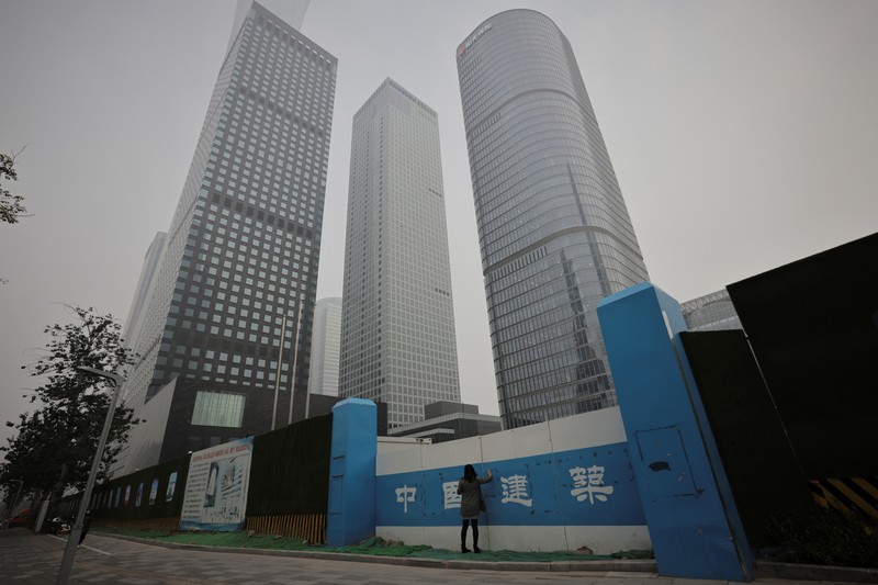 People overlook the skyline of the Central Business District on a polluted day in Beijing, China, November 5, 2021.  REUTERS/Thomas Peter