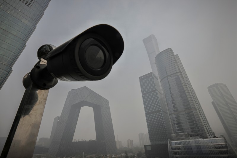 People overlook the skyline of the Central Business District on a polluted day in Beijing, China, November 5, 2021.  REUTERS/Thomas Peter