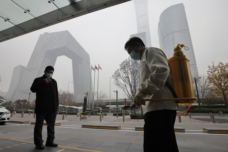 People overlook the skyline of the Central Business District on a polluted day in Beijing, China, November 5, 2021.  REUTERS/Thomas Peter
