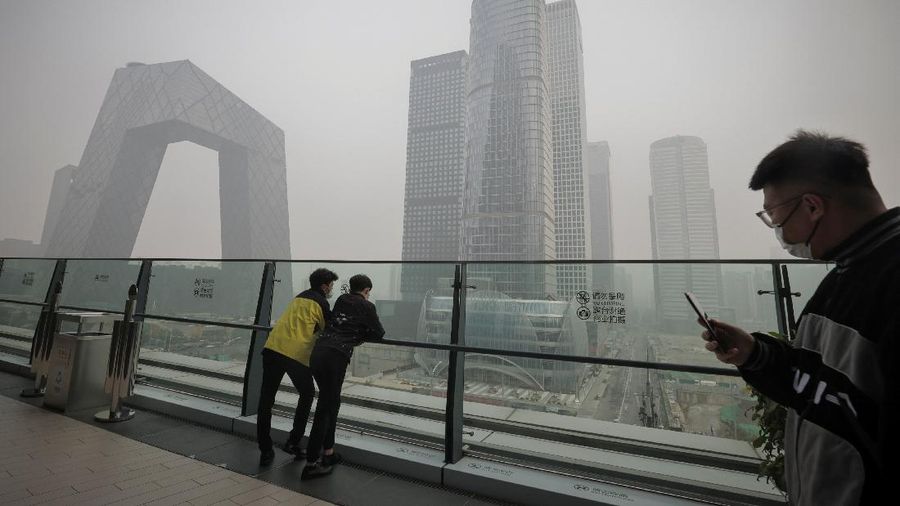 People overlook the skyline of the Central Business District on a polluted day in Beijing, China, November 5, 2021.  REUTERS/Thomas Peter