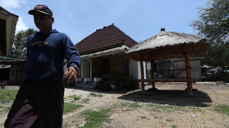 Petugas berbincang dengan warga berlatar belakang Sarana Hunian Pariwisata atau Sarhunta di Kampung Homestay di Dusun Bangan, Desa Sengkol, Kecamatan Pujut, Lombok Tengah, Nusa Tenggara Barat, Jumat (5/11/2021). Kementerian PUPR melalui Balai Pelaksana Penyediaan Perumahan Nusa Tenggara I (BPPNT I) meningkatkan kualitas 300 rumah tak layak huni menjadi Sarana Hunian Pariwisata atau Sarhunta. Balai Perumahan, Kasi Wilayah 2 Nusa Tenggara Barat Dudi Mustofa, mengatakan kegiatan peningkatan kualitas hunian dimulai dari tahun 2020, tepatnya perencanaan di bulan Mei dan pelaksanaan fisik kegiatannya tanggal 17 Agustus 2020 sampai dengan 31 Desember 2020. Berada di Kawasan Mandalika ada 300 rumah dan di kawasan Gili Air ada 98 rumah,