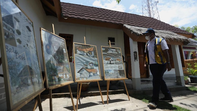 Petugas berbincang dengan warga berlatar belakang Sarana Hunian Pariwisata atau Sarhunta di Kampung Homestay di Dusun Bangan, Desa Sengkol, Kecamatan Pujut, Lombok Tengah, Nusa Tenggara Barat, Jumat (5/11/2021). Kementerian PUPR melalui Balai Pelaksana Penyediaan Perumahan Nusa Tenggara I (BPPNT I) meningkatkan kualitas 300 rumah tak layak huni menjadi Sarana Hunian Pariwisata atau Sarhunta. Balai Perumahan, Kasi Wilayah 2 Nusa Tenggara Barat Dudi Mustofa, mengatakan kegiatan peningkatan kualitas hunian dimulai dari tahun 2020, tepatnya perencanaan di bulan Mei dan pelaksanaan fisik kegiatannya tanggal 17 Agustus 2020 sampai dengan 31 Desember 2020. Berada di Kawasan Mandalika ada 300 rumah dan di kawasan Gili Air ada 98 rumah,