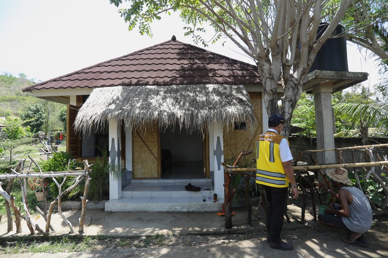 Sarana Hunian Pariwisata atau Sarhunta di Kampung Homestay di Dusun Bangan, Desa Sengkol, Kecamatan Pujut, Lombok Tengah, Nusa Tenggara Barat, Jumat (5/11/2021). Petugas berbincang dengan warga berlatar belakang Sarana Hunian Pariwisata atau Sarhunta di Kampung Homestay di Dusun Bangan, Desa Sengkol, Kecamatan Pujut, Lombok Tengah, Nusa Tenggara Barat, Jumat (5/11/2021). Kementerian PUPR melalui Balai Pelaksana Penyediaan Perumahan Nusa Tenggara I (BPPNT I) meningkatkan kualitas 300 rumah tak layak huni menjadi Sarana Hunian Pariwisata atau Sarhunta. Balai Perumahan, Kasi Wilayah 2 Nusa Tenggara Barat Dudi Mustofa, mengatakan kegiatan peningkatan kualitas hunian dimulai dari tahun 2020, tepatnya perencanaan di bulan Mei dan pelaksanaan fisik kegiatannya tanggal 17 Agustus 2020 sampai dengan 31 Desember 2020. Berada di Kawasan Mandalika ada 300 rumah dan di kawasan Gili Air ada 98 rumah,