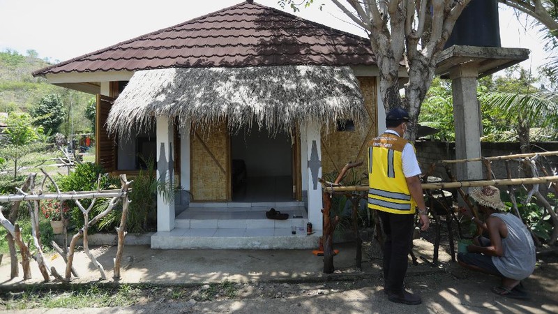 Petugas berbincang dengan warga berlatar belakang Sarana Hunian Pariwisata atau Sarhunta di Kampung Homestay di Dusun Bangan, Desa Sengkol, Kecamatan Pujut, Lombok Tengah, Nusa Tenggara Barat, Jumat (5/11/2021). Kementerian PUPR melalui Balai Pelaksana Penyediaan Perumahan Nusa Tenggara I (BPPNT I) meningkatkan kualitas 300 rumah tak layak huni menjadi Sarana Hunian Pariwisata atau Sarhunta. Balai Perumahan, Kasi Wilayah 2 Nusa Tenggara Barat Dudi Mustofa, mengatakan kegiatan peningkatan kualitas hunian dimulai dari tahun 2020, tepatnya perencanaan di bulan Mei dan pelaksanaan fisik kegiatannya tanggal 17 Agustus 2020 sampai dengan 31 Desember 2020. Berada di Kawasan Mandalika ada 300 rumah dan di kawasan Gili Air ada 98 rumah,