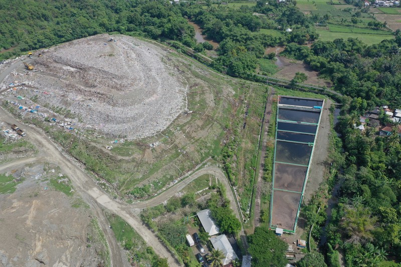 Tempat Pembuangan Akhir (TPA) Regional Kebon Kongok, Kabupaten Lombok Barat, Foto udara gunungan sampah di Tempat Pembuangan Akhir (TPA) Regional Kebon Kongok, Kabupaten Lombok Barat, Jumat (5/11/2021). Lokasi ini merupakan tempat pemilahan sampah organik dan anorganik, di komplek TPA terbesar di Nusa Tenggara Barat NTB. Dari sini, proses pengolahan sampah menjadi pelet RDF (Refuse Derived Fuel) dibuat, yang merupakan pengganti bahan bakar batubara di Pembangkit Listrik Tenaga Uap (PLTU) Jeranjang, Lombok Barat. Sampah diproses di mesin pencacah ukuran 5-8 mm untuk berikutnya dimasukkan ke mesin pengepresan menjadi pelet RDF. Pelet akan dikeringkan di bawah sinar matahari sebelum dikirim ke PLTU Jeranjang. Di pembangkit listrik itu pelet dibakar melalui sistem co-firing.
Setiap hari, sekitar 300 ton sampah dari Kota Mataram dan Lombok Barat diantar ke TPA ini. Namun, menurut jumlah yang diolah menjadi pellet baru 100 hingga 200 kilogram.
Kementerian PUPR memfasilitasi lahan seluas 40 are (4 ribu meter persegi) di sekitar TPA. Di bangunan tersebut, semua fasilitas yang dibutuhkan untuk pengolahan sampah menjadi pellet disediakan.
Penelitian masih dilakukan agar sampah non-organik bisa lebih banyak diolah. Saat ini, komposisi pelet terdiri 95 persen sampah organik dan 5 persen anorganik. (CNBC Indonesia/ Tri Susilo)