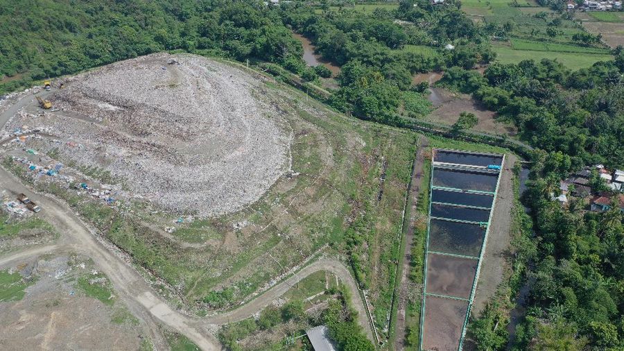 Foto udara gunungan sampah di Tempat Pembuangan Akhir (TPA) Regional Kebon Kongok, Kabupaten Lombok Barat, Jumat (5/11/2021).  Lokasi ini merupakan tempat pemilahan sampah organik dan anorganik, di komplek TPA terbesar di Nusa Tenggara Barat NTB. Dari sini, proses pengolahan sampah menjadi pelet RDF (Refuse Derived Fuel) dibuat, yang merupakan pengganti bahan bakar batubara di Pembangkit Listrik Tenaga Uap (PLTU) Jeranjang, Lombok Barat. Sampah diproses di mesin pencacah ukuran 5-8 mm untuk berikutnya dimasukkan ke mesin pengepresan menjadi pelet RDF. Pelet akan dikeringkan di bawah sinar matahari sebelum dikirim ke PLTU Jeranjang. Di pembangkit listrik itu pelet dibakar melalui sistem co-firing.
Setiap hari, sekitar 300 ton sampah dari Kota Mataram dan Lombok Barat diantar ke TPA ini. Namun, menurut jumlah yang diolah menjadi pellet baru 100 hingga 200 kilogram. 
Kementerian PUPR memfasilitasi lahan seluas 40 are (4 ribu meter persegi) di sekitar TPA. Di bangunan tersebut, semua fasilitas yang dibutuhkan untuk pengolahan sampah menjadi pellet disediakan. 
Penelitian masih dilakukan agar sampah non-organik bisa lebih banyak diolah. Saat ini, komposisi pelet terdiri 95 persen sampah organik dan 5 persen anorganik. (CNBC Indonesia/ Tri Susilo)