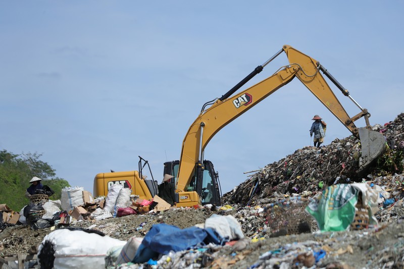 Tempat Pembuangan Akhir (TPA) Regional Kebon Kongok, Kabupaten Lombok Barat, Foto udara gunungan sampah di Tempat Pembuangan Akhir (TPA) Regional Kebon Kongok, Kabupaten Lombok Barat, Jumat (5/11/2021). Lokasi ini merupakan tempat pemilahan sampah organik dan anorganik, di komplek TPA terbesar di Nusa Tenggara Barat NTB. Dari sini, proses pengolahan sampah menjadi pelet RDF (Refuse Derived Fuel) dibuat, yang merupakan pengganti bahan bakar batubara di Pembangkit Listrik Tenaga Uap (PLTU) Jeranjang, Lombok Barat. Sampah diproses di mesin pencacah ukuran 5-8 mm untuk berikutnya dimasukkan ke mesin pengepresan menjadi pelet RDF. Pelet akan dikeringkan di bawah sinar matahari sebelum dikirim ke PLTU Jeranjang. Di pembangkit listrik itu pelet dibakar melalui sistem co-firing.
Setiap hari, sekitar 300 ton sampah dari Kota Mataram dan Lombok Barat diantar ke TPA ini. Namun, menurut jumlah yang diolah menjadi pellet baru 100 hingga 200 kilogram.
Kementerian PUPR memfasilitasi lahan seluas 40 are (4 ribu meter persegi) di sekitar TPA. Di bangunan tersebut, semua fasilitas yang dibutuhkan untuk pengolahan sampah menjadi pellet disediakan.
Penelitian masih dilakukan agar sampah non-organik bisa lebih banyak diolah. Saat ini, komposisi pelet terdiri 95 persen sampah organik dan 5 persen anorganik. (CNBC Indonesia/ Tri Susilo)