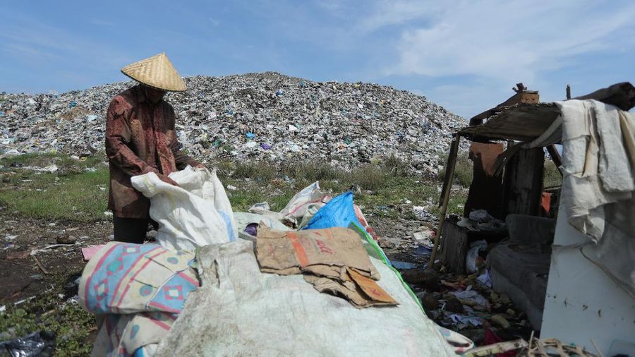 Foto udara gunungan sampah di Tempat Pembuangan Akhir (TPA) Regional Kebon Kongok, Kabupaten Lombok Barat, Jumat (5/11/2021).  Lokasi ini merupakan tempat pemilahan sampah organik dan anorganik, di komplek TPA terbesar di Nusa Tenggara Barat NTB. Dari sini, proses pengolahan sampah menjadi pelet RDF (Refuse Derived Fuel) dibuat, yang merupakan pengganti bahan bakar batubara di Pembangkit Listrik Tenaga Uap (PLTU) Jeranjang, Lombok Barat. Sampah diproses di mesin pencacah ukuran 5-8 mm untuk berikutnya dimasukkan ke mesin pengepresan menjadi pelet RDF. Pelet akan dikeringkan di bawah sinar matahari sebelum dikirim ke PLTU Jeranjang. Di pembangkit listrik itu pelet dibakar melalui sistem co-firing.
Setiap hari, sekitar 300 ton sampah dari Kota Mataram dan Lombok Barat diantar ke TPA ini. Namun, menurut jumlah yang diolah menjadi pellet baru 100 hingga 200 kilogram. 
Kementerian PUPR memfasilitasi lahan seluas 40 are (4 ribu meter persegi) di sekitar TPA. Di bangunan tersebut, semua fasilitas yang dibutuhkan untuk pengolahan sampah menjadi pellet disediakan. 
Penelitian masih dilakukan agar sampah non-organik bisa lebih banyak diolah. Saat ini, komposisi pelet terdiri 95 persen sampah organik dan 5 persen anorganik. (CNBC Indonesia/ Tri Susilo)