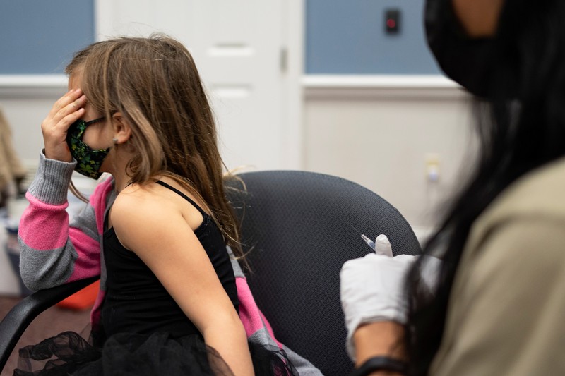 Vaksin Covid-19 Untuk Anak di AS Nora Gossett, 7, reacts as she receives the Pfizer-BioNTech COVID-19 vaccine from Sophia Jan, MD, while her father Jeff Gossett, MD, holds her hand at Cohen Children's Medical Center as vaccines were approved for children aged 5-11, amid the coronavirus disease pandemic, in New Hyde Park, New York, U.S., November 4, 2021. REUTERS/Andrew Kelly