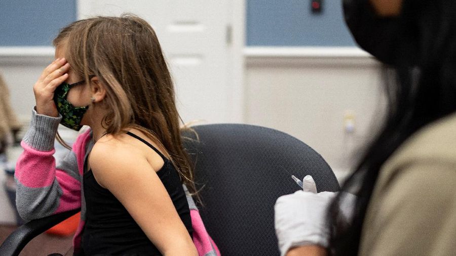 Nora Gossett, 7, reacts as she receives the Pfizer-BioNTech COVID-19 vaccine from Sophia Jan, MD, while her father Jeff Gossett, MD, holds her hand at Cohen Children's Medical Center as vaccines were approved for children aged 5-11, amid the coronavirus disease pandemic, in New Hyde Park, New York, U.S., November 4, 2021. REUTERS/Andrew Kelly