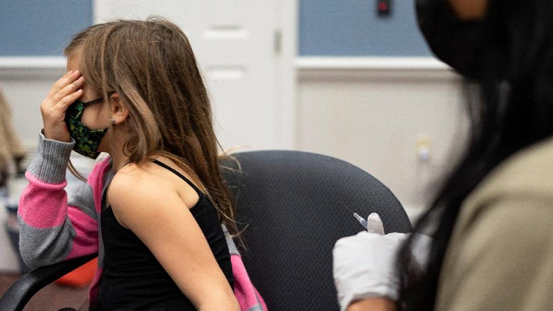 Nora Gossett, 7, reacts as she receives the Pfizer-BioNTech COVID-19 vaccine from Sophia Jan, MD, while her father Jeff Gossett, MD, holds her hand at Cohen Children's Medical Center as vaccines were approved for children aged 5-11, amid the coronavirus disease pandemic, in New Hyde Park, New York, U.S., November 4, 2021. REUTERS/Andrew Kelly