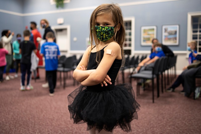 Vaksin Covid-19 Untuk Anak di AS Nora Gossett, 7, reacts as she receives the Pfizer-BioNTech COVID-19 vaccine from Sophia Jan, MD, while her father Jeff Gossett, MD, holds her hand at Cohen Children's Medical Center as vaccines were approved for children aged 5-11, amid the coronavirus disease pandemic, in New Hyde Park, New York, U.S., November 4, 2021. REUTERS/Andrew Kelly