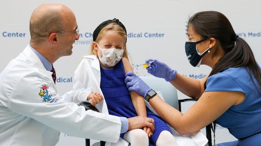Nora Gossett, 7, reacts as she receives the Pfizer-BioNTech COVID-19 vaccine from Sophia Jan, MD, while her father Jeff Gossett, MD, holds her hand at Cohen Children's Medical Center as vaccines were approved for children aged 5-11, amid the coronavirus disease pandemic, in New Hyde Park, New York, U.S., November 4, 2021. REUTERS/Andrew Kelly
