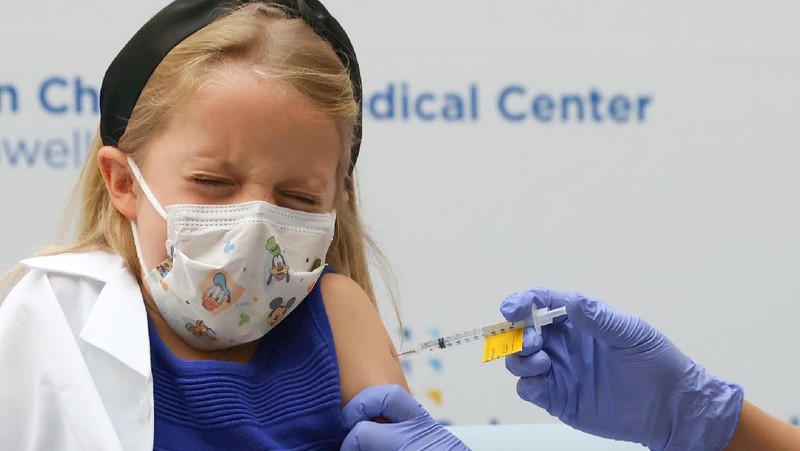Nora Gossett, 7, reacts as she receives the Pfizer-BioNTech COVID-19 vaccine from Sophia Jan, MD, while her father Jeff Gossett, MD, holds her hand at Cohen Children's Medical Center as vaccines were approved for children aged 5-11, amid the coronavirus disease pandemic, in New Hyde Park, New York, U.S., November 4, 2021. REUTERS/Andrew Kelly