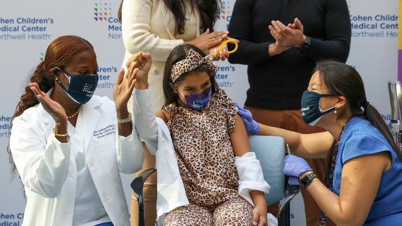 Nora Gossett, 7, reacts as she receives the Pfizer-BioNTech COVID-19 vaccine from Sophia Jan, MD, while her father Jeff Gossett, MD, holds her hand at Cohen Children's Medical Center as vaccines were approved for children aged 5-11, amid the coronavirus disease pandemic, in New Hyde Park, New York, U.S., November 4, 2021. REUTERS/Andrew Kelly
