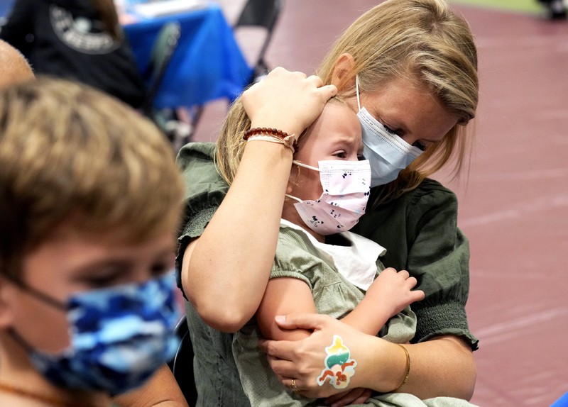 Vaksin Covid-19 Untuk Anak di AS Nora Gossett, 7, reacts as she receives the Pfizer-BioNTech COVID-19 vaccine from Sophia Jan, MD, while her father Jeff Gossett, MD, holds her hand at Cohen Children's Medical Center as vaccines were approved for children aged 5-11, amid the coronavirus disease pandemic, in New Hyde Park, New York, U.S., November 4, 2021. REUTERS/Andrew Kelly