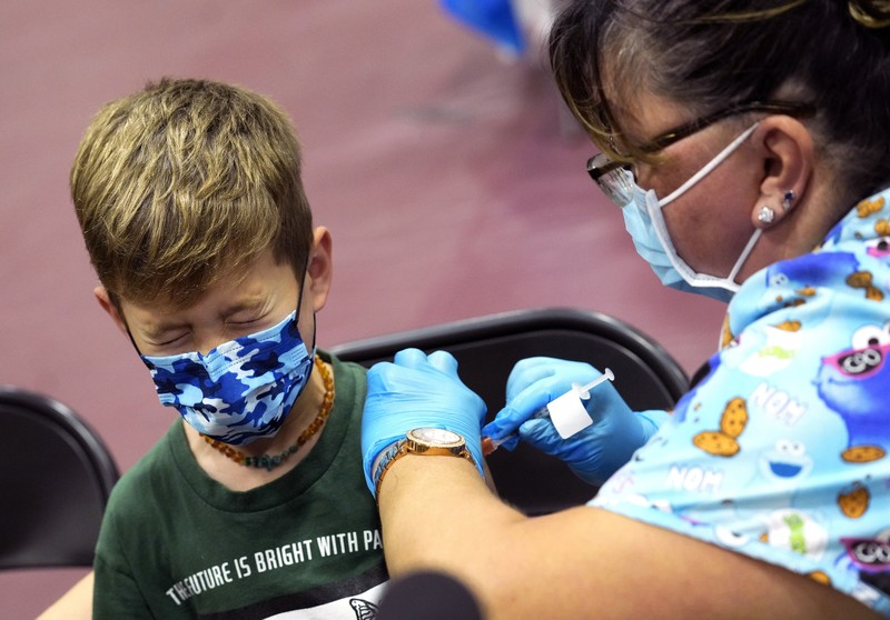 Nora Gossett, 7, reacts as she receives the Pfizer-BioNTech COVID-19 vaccine from Sophia Jan, MD, while her father Jeff Gossett, MD, holds her hand at Cohen Children's Medical Center as vaccines were approved for children aged 5-11, amid the coronavirus disease pandemic, in New Hyde Park, New York, U.S., November 4, 2021. REUTERS/Andrew Kelly
