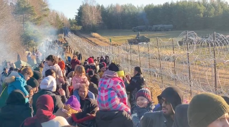 Para migran berkumpul di dekat pagar kawat berduri dalam upaya melintasi perbatasan dengan Polandia di wilayah Grodno, Belarusia. (via REUTERS/OBTAINED BY REUTERS)