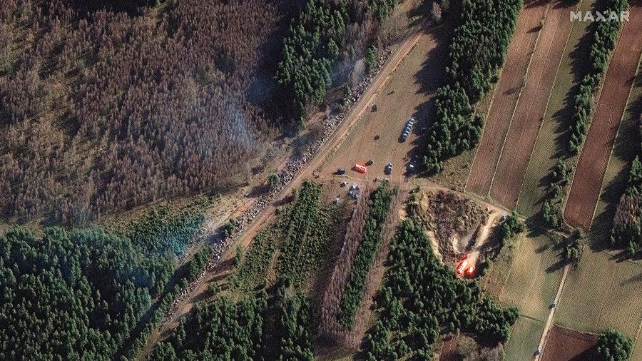 Para migran berkumpul di dekat pagar kawat berduri dalam upaya melintasi perbatasan dengan Polandia di wilayah Grodno, Belarusia. (via REUTERS/OBTAINED BY REUTERS)
