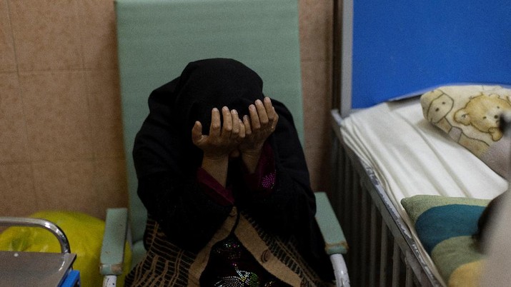 An Afghan woman reacts as she takes care of her son at the malnutrition ward of the Indira Gandhi Children's hospital in Kabul, Afghanistan October 23, 2021. REUTERS/Jorge Silva