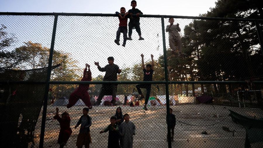 Afghan children, displaced with their families fleeing the violence in their province climb a fence at Shahr-e Naw park, in Kabul, Afghanistan, October 14, 2021. REUTERS/Zohra Bensemra