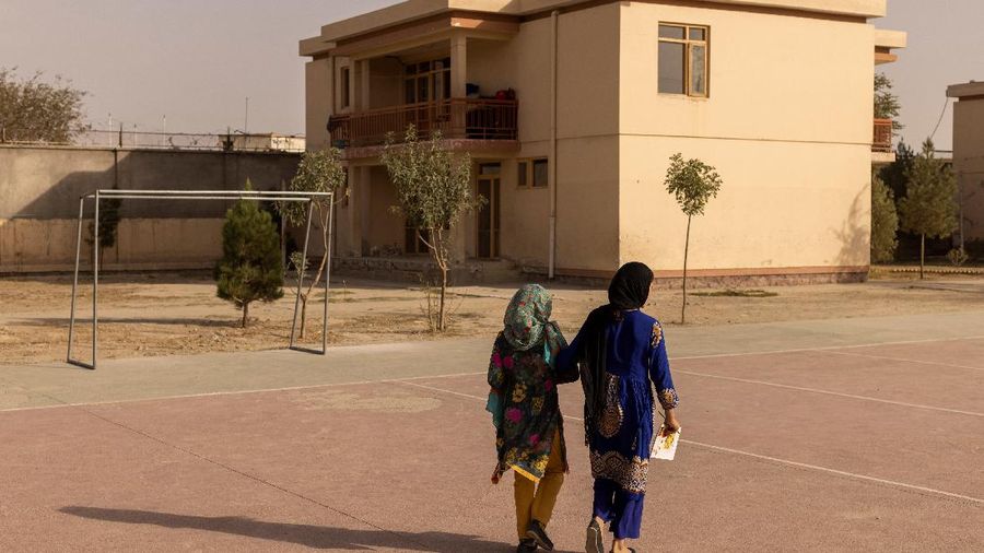 Samira, 9, and a friend walk to Samira's house after attending lessons at the orphanage in Kabul, Afghanistan, October 10, 2021. Samira wants to be a doctor when she grows up.