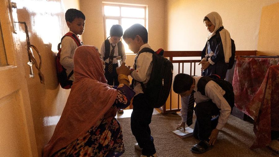 Golshan, a childcare worker, gets the children ready for school at the orphanage in Kabul, Afghanistan, October 12, 2021. Orphanages like this play an outsize role in Afghanistan, where tens of thousands of civilians have been killed in wars that have ravaged the country for more than 40 years. The lack of funding, which has hit charities, non-governmental organisations and ordinary Afghans since the hardline Islamist Taliban movement took back control of the country, is forcing orphanage director Ahmad Khalil Mayan (not pictured) into tough choices. 