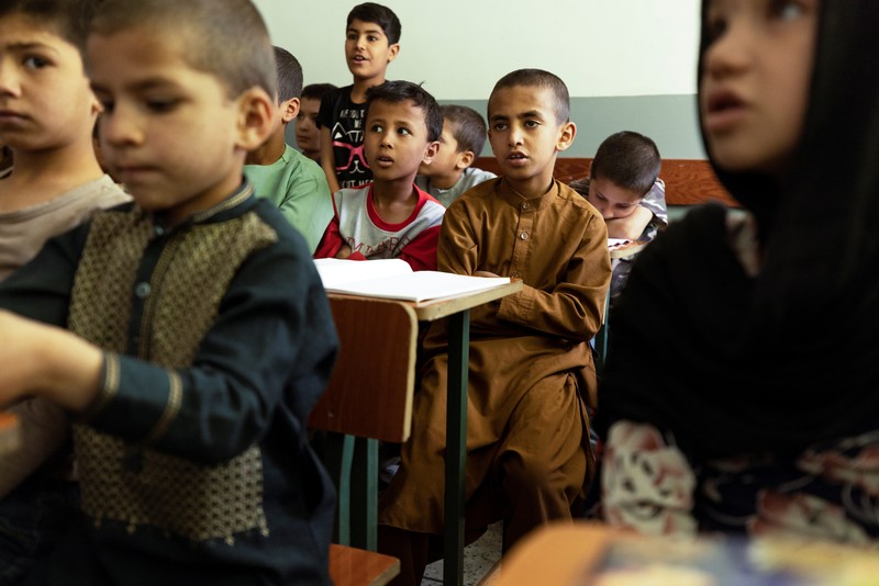 Golshan, a childcare worker at the orphanage, serves the children tea and bread for breakfast in Kabul, Afghanistan, October 12, 2021. Orphanages like this play an outsize role in Afghanistan, where tens of thousands of civilians have been killed in wars that have ravaged the country for more than 40 years. The lack of funding, which has hit charities, non-governmental organisations and ordinary Afghans since the hardline Islamist Taliban movement took back control of the country, is forcing orphanage director Ahmad Khalil Mayan (not pictured) into tough choices. 