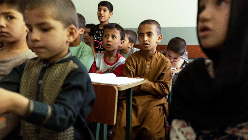Golshan, a childcare worker at the orphanage, serves the children tea and bread for breakfast in Kabul, Afghanistan, October 12, 2021. Orphanages like this play an outsize role in Afghanistan, where tens of thousands of civilians have been killed in wars that have ravaged the country for more than 40 years. The lack of funding, which has hit charities, non-governmental organisations and ordinary Afghans since the hardline Islamist Taliban movement took back control of the country, is forcing orphanage director Ahmad Khalil Mayan (not pictured) into tough choices. 