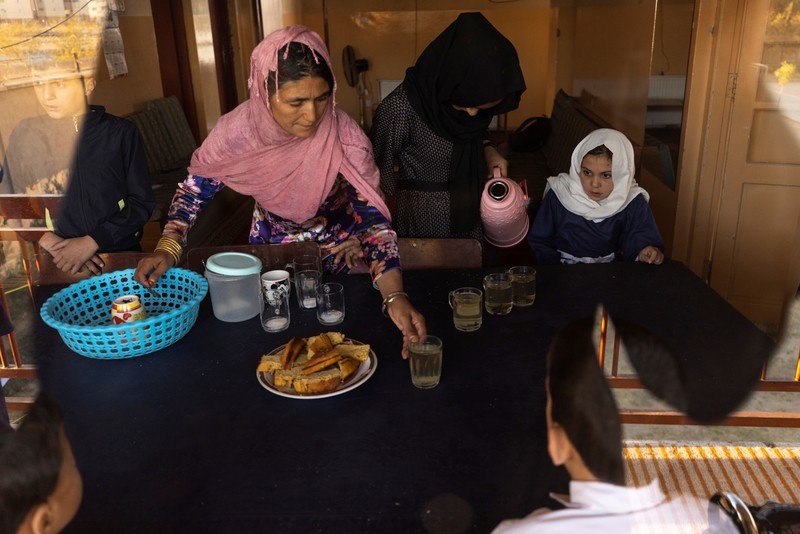 Golshan, a childcare worker at the orphanage, serves the children tea and bread for breakfast in Kabul, Afghanistan, October 12, 2021. Orphanages like this play an outsize role in Afghanistan, where tens of thousands of civilians have been killed in wars that have ravaged the country for more than 40 years. The lack of funding, which has hit charities, non-governmental organisations and ordinary Afghans since the hardline Islamist Taliban movement took back control of the country, is forcing orphanage director Ahmad Khalil Mayan (not pictured) into tough choices. 