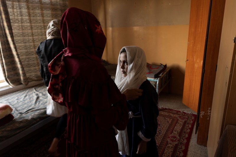 Golshan, a childcare worker at the orphanage, serves the children tea and bread for breakfast in Kabul, Afghanistan, October 12, 2021. Orphanages like this play an outsize role in Afghanistan, where tens of thousands of civilians have been killed in wars that have ravaged the country for more than 40 years. The lack of funding, which has hit charities, non-governmental organisations and ordinary Afghans since the hardline Islamist Taliban movement took back control of the country, is forcing orphanage director Ahmad Khalil Mayan (not pictured) into tough choices. 