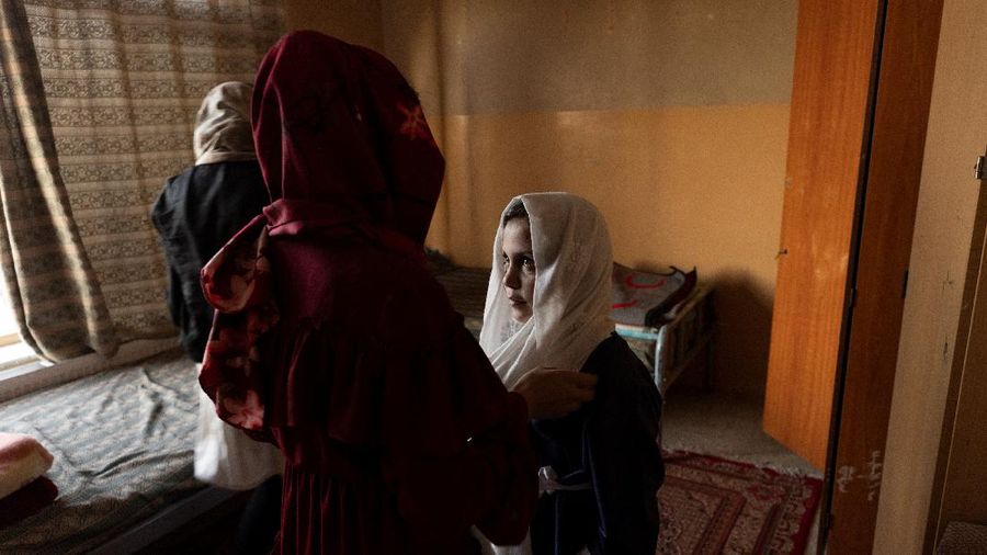 Golshan, a childcare worker at the orphanage, serves the children tea and bread for breakfast in Kabul, Afghanistan, October 12, 2021. Orphanages like this play an outsize role in Afghanistan, where tens of thousands of civilians have been killed in wars that have ravaged the country for more than 40 years. The lack of funding, which has hit charities, non-governmental organisations and ordinary Afghans since the hardline Islamist Taliban movement took back control of the country, is forcing orphanage director Ahmad Khalil Mayan (not pictured) into tough choices. 