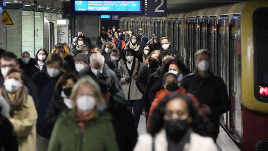Commuters wearing face masks to protect against the coronavirus as they arrives at the public transport station Brandenburger Tor in central Berlin, Germany, Friday, Nov. 12, 2021. Germany battles a fourth wave of the coronavirus with high number of infections in the recent days. (AP Photo/Markus Schreiber)