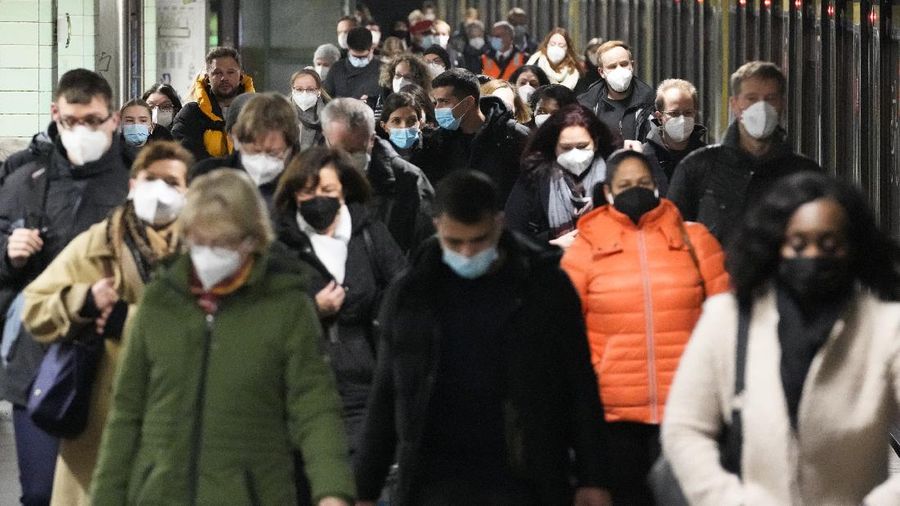Commuters wearing face masks to protect against the coronavirus as they arrives at the public transport station Brandenburger Tor in central Berlin, Germany, Friday, Nov. 12, 2021. Germany battles a fourth wave of the coronavirus with high number of infections in the recent days. (AP Photo/Markus Schreiber)