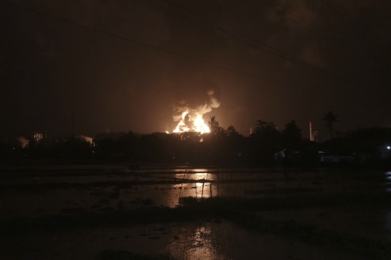 Indonesia Refinery Fire The sky glows from the fire that razes through an oil refinery owned by the national oil company Pertamina, in Cilacap, Central Java, Indonesia, Saturday, Nov. 13, 2021. The fire at a gasoline storage at the largest oil refinery on Indonesia's Java island prompted the evacuation of dozens of residents living nearby. (AP Photo/Agus Fitrah)