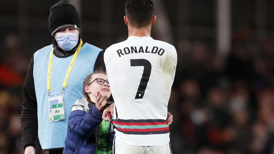 Portugal's Cristiano Ronaldo gives his shirt to a young fan who walked on to the pitch at the end of the World Cup 2022 group A qualifying soccer match between the Republic of Ireland and Portugal at the Aviva stadium in Dublin, Thursday, Nov. 11, 2021. The game ended in a goalless draw. (AP Photo/Peter Morrison)
