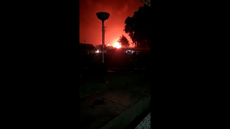 The sky glows from the fire that razes through an oil refinery owned by the national oil company Pertamina, in Cilacap, Central Java, Indonesia, Saturday, Nov. 13, 2021. The fire at a gasoline storage at the largest oil refinery on Indonesia's Java island prompted the evacuation of dozens of residents living nearby. (AP Photo/Agus Fitrah)