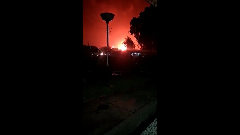 The sky glows from the fire that razes through an oil refinery owned by the national oil company Pertamina, in Cilacap, Central Java, Indonesia, Saturday, Nov. 13, 2021. The fire at a gasoline storage at the largest oil refinery on Indonesia's Java island prompted the evacuation of dozens of residents living nearby. (AP Photo/Agus Fitrah)