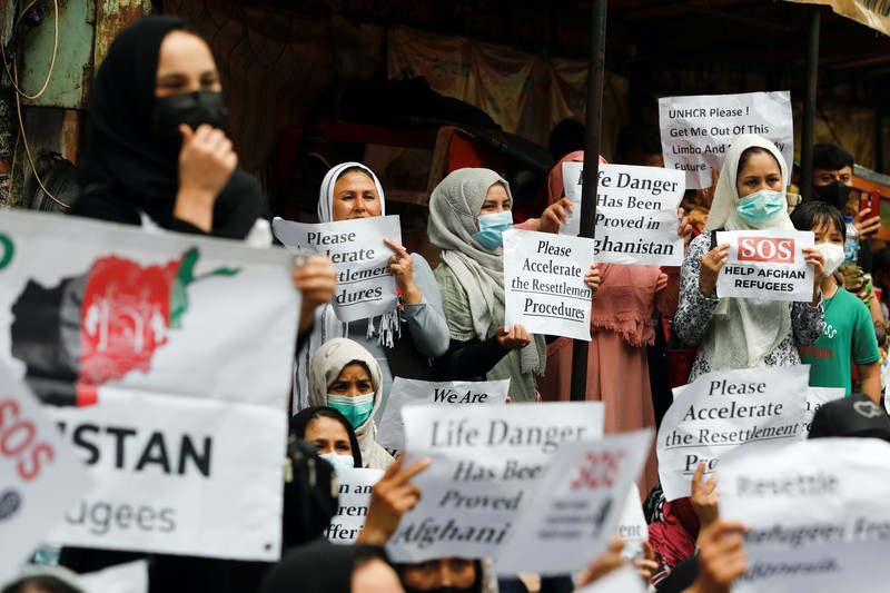 Indonesia Afghan Refugees Afghan women and children refugees living in Indonesia hold posters during a rally outside a building that houses UNHCR representative office in Jakarta, Indonesia, Monday, Nov. 15, 2021. Hundreds of Afghan refugees and asylum seekers living in Indonesia rallied in front of the U.N. refugee agency office in Jakarta on Monday to urge it to speed up their resettlement.(AP Photo/Achmad Ibrahim)