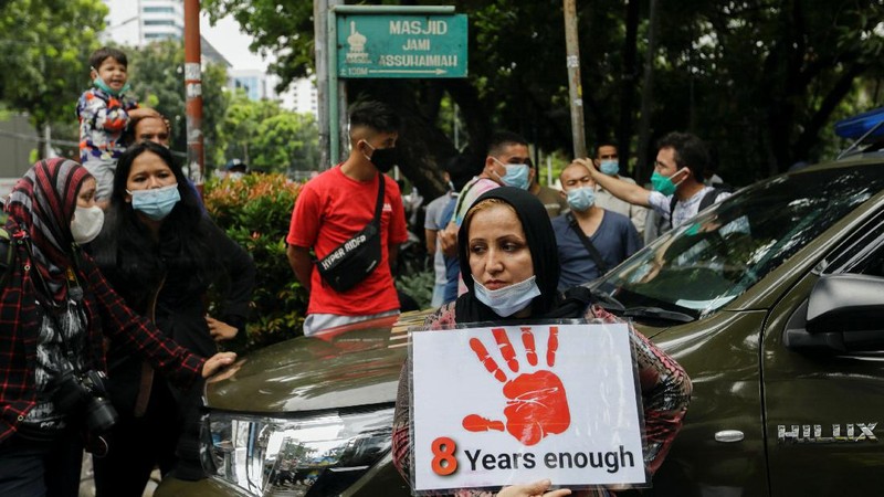 Afghan women and children refugees living in Indonesia hold posters during a rally outside a building that houses UNHCR representative office in Jakarta, Indonesia, Monday, Nov. 15, 2021. Hundreds of Afghan refugees and asylum seekers living in Indonesia rallied in front of the U.N. refugee agency office in Jakarta on Monday to urge it to speed up their resettlement.(AP Photo/Achmad Ibrahim)