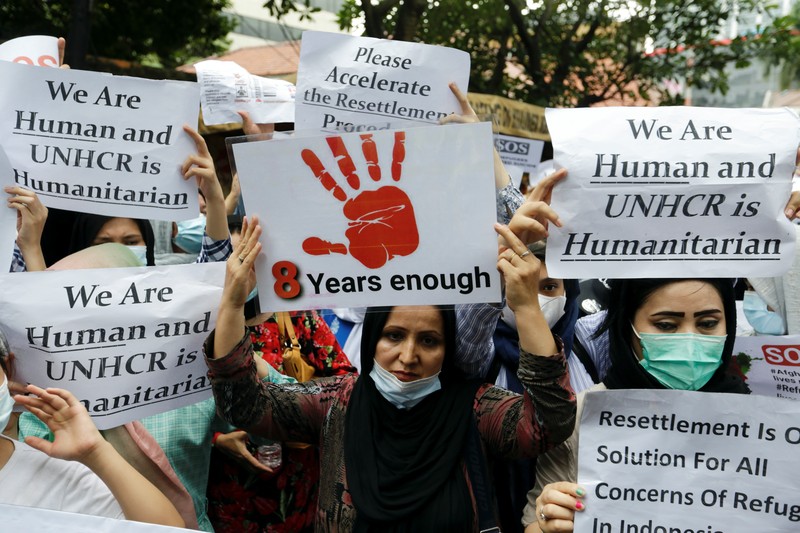 Indonesia Afghan Refugees Afghan women and children refugees living in Indonesia hold posters during a rally outside a building that houses UNHCR representative office in Jakarta, Indonesia, Monday, Nov. 15, 2021. Hundreds of Afghan refugees and asylum seekers living in Indonesia rallied in front of the U.N. refugee agency office in Jakarta on Monday to urge it to speed up their resettlement.(AP Photo/Achmad Ibrahim)