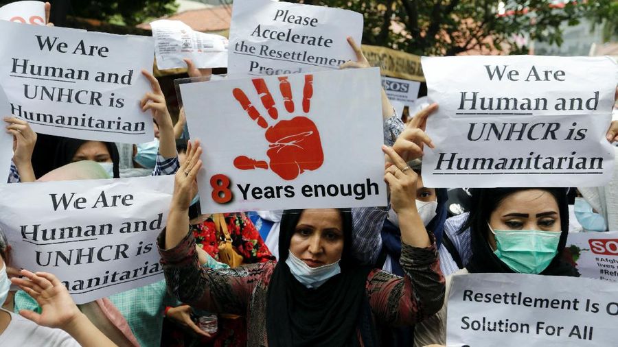 Afghan refugees hold placards to ask for justice and process resettlement within 36 months during a rally outside the UN Refugee Agency UNHCR's office in Jakarta, Indonesia, November 15, 2021. REUTERS/Ajeng Dinar Ulfiana
