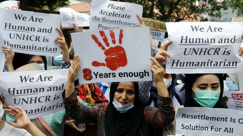 Afghan women and children refugees living in Indonesia hold posters during a rally outside a building that houses UNHCR representative office in Jakarta, Indonesia, Monday, Nov. 15, 2021. Hundreds of Afghan refugees and asylum seekers living in Indonesia rallied in front of the U.N. refugee agency office in Jakarta on Monday to urge it to speed up their resettlement.(AP Photo/Achmad Ibrahim)