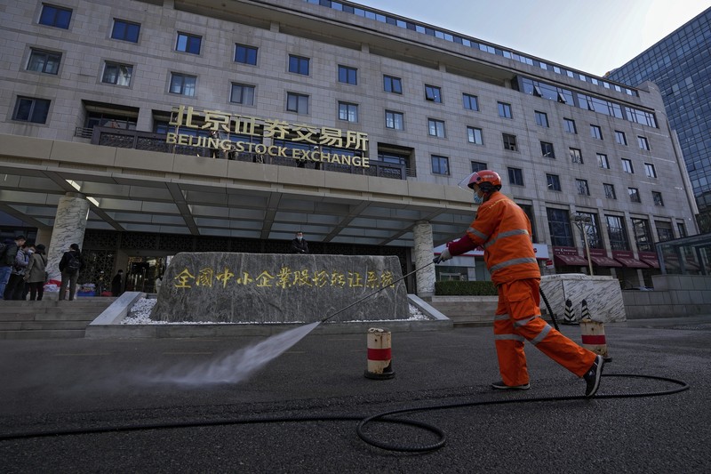 CHINA-EXCHANGE/TRADING Men are seen near the new Beijing Stock Exchange building at the Financial Street, in Beijing, China, November 15, 2021. REUTERS/Tingshu Wang