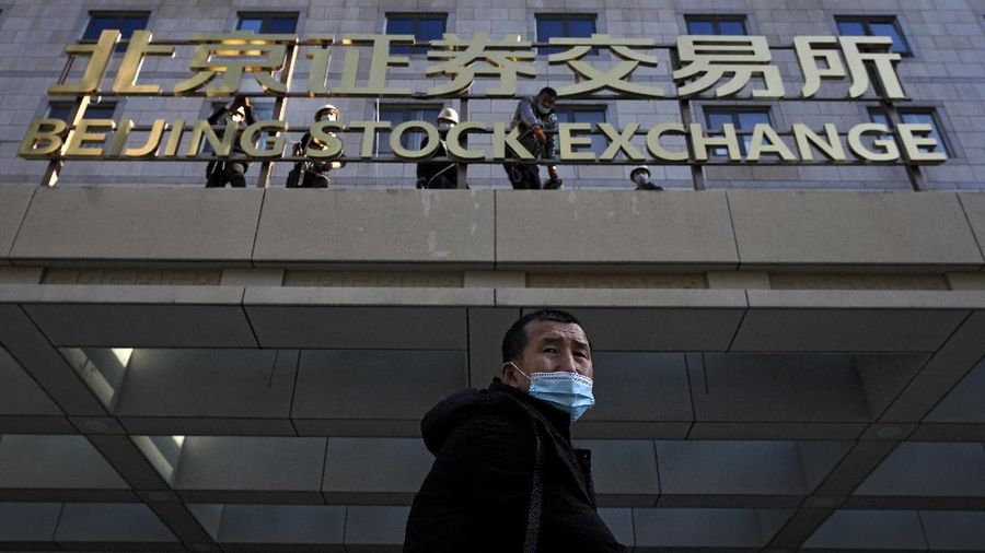 Men are seen near the new Beijing Stock Exchange building at the Financial Street, in Beijing, China, November 15, 2021. REUTERS/Tingshu Wang