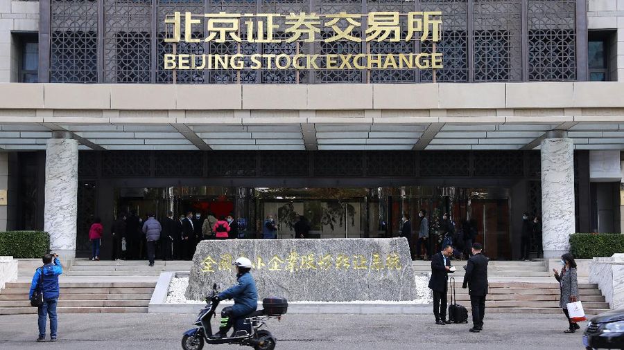 Men are seen near the new Beijing Stock Exchange building at the Financial Street, in Beijing, China, November 15, 2021. REUTERS/Tingshu Wang